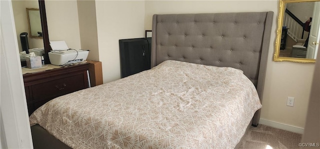 bedroom featuring light colored carpet and baseboards