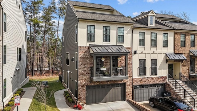 townhome / multi-family property featuring brick siding, driveway, an attached garage, and stucco siding