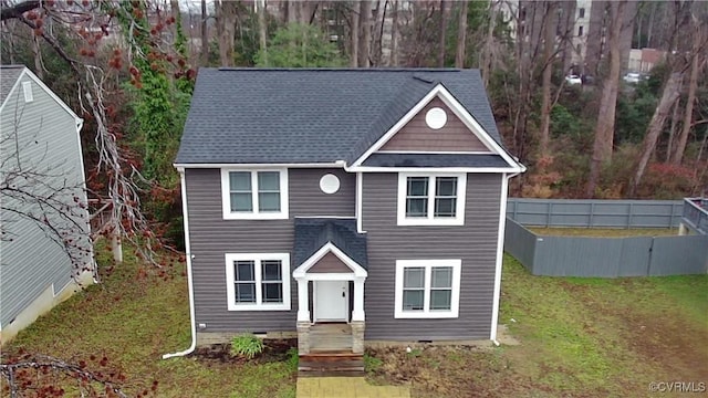 view of front of home with a shingled roof, crawl space, and a front yard