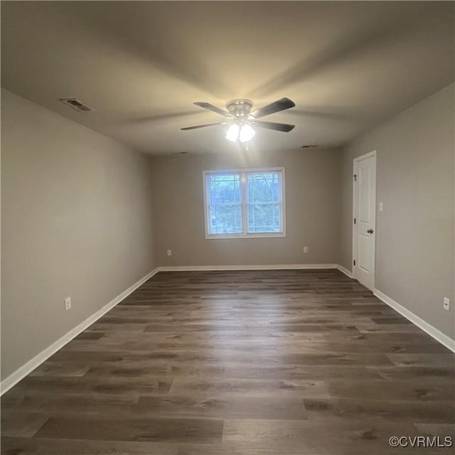 empty room with a ceiling fan, baseboards, visible vents, and dark wood-style flooring