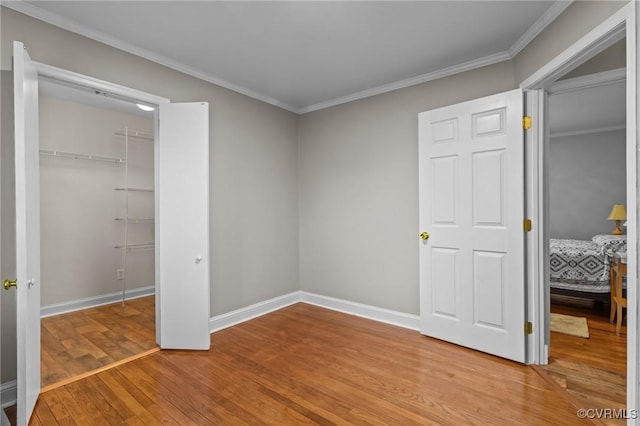 unfurnished bedroom with light wood-style flooring, ornamental molding, and baseboards