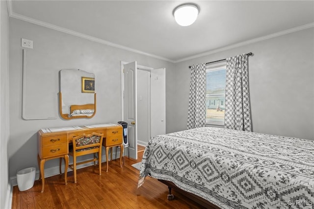 bedroom featuring ornamental molding, wood finished floors, and baseboards