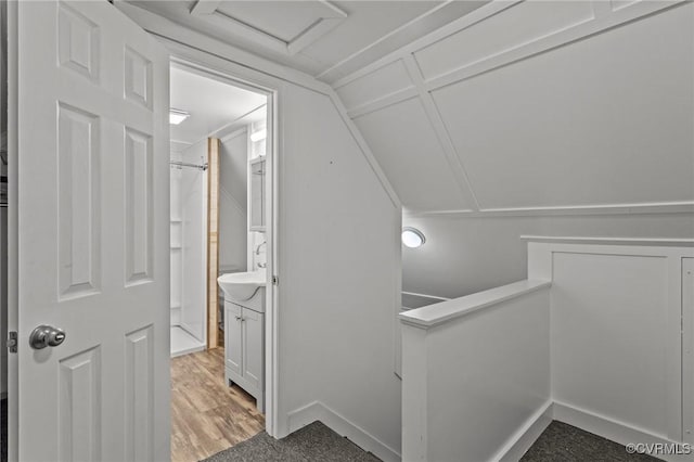 interior space featuring lofted ceiling, wood finished floors, and an upstairs landing