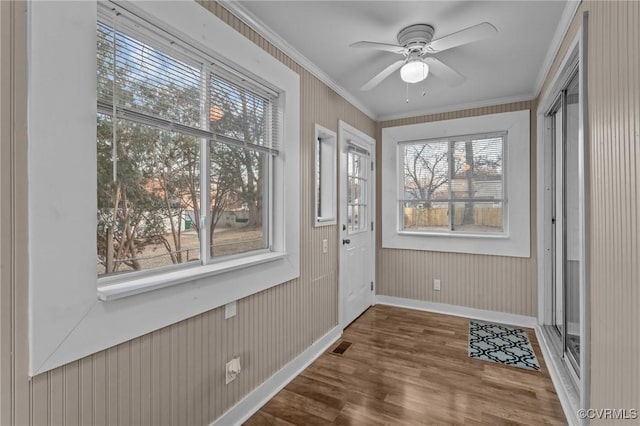 entryway with wood finished floors, a ceiling fan, baseboards, visible vents, and crown molding