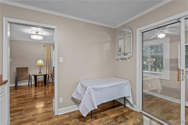 dining area with crown molding, baseboards, and wood finished floors