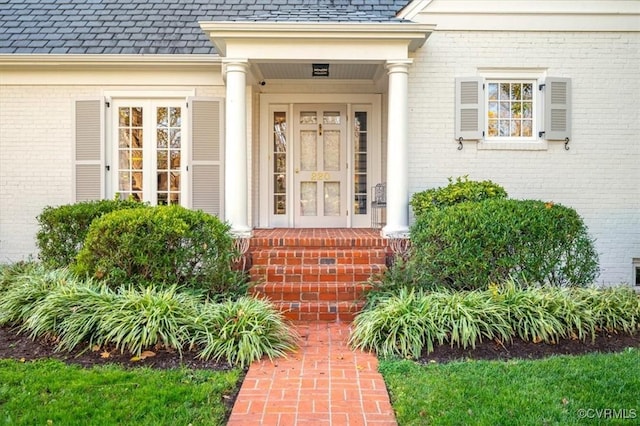 property entrance with a high end roof and brick siding