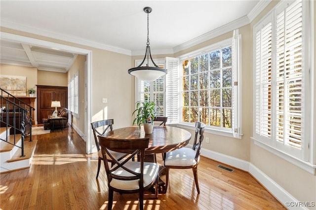 dining space with stairs, a wealth of natural light, visible vents, and hardwood / wood-style floors