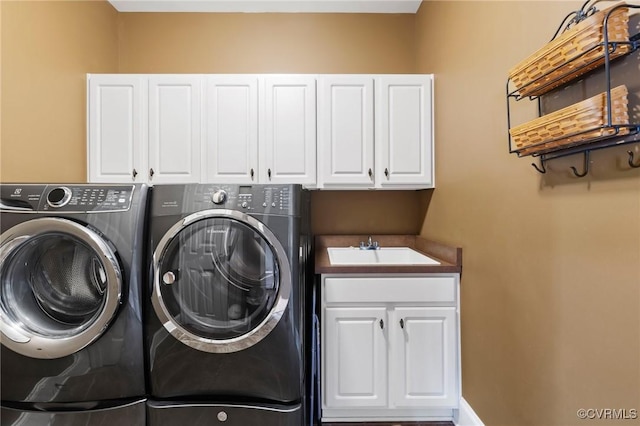 clothes washing area with separate washer and dryer, cabinet space, and a sink