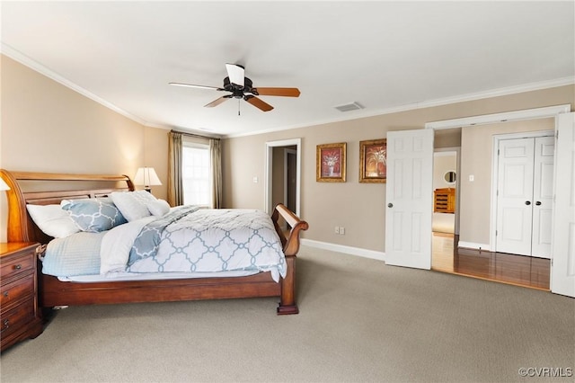 carpeted bedroom featuring visible vents, a ceiling fan, baseboards, and ornamental molding