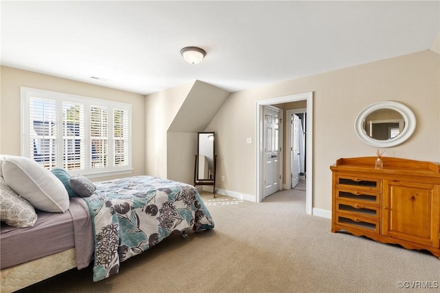 bedroom with light carpet, lofted ceiling, and baseboards