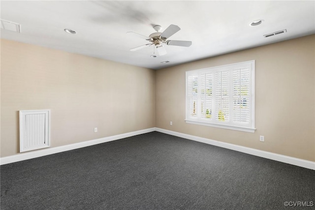 unfurnished room with dark carpet, visible vents, baseboards, and a ceiling fan