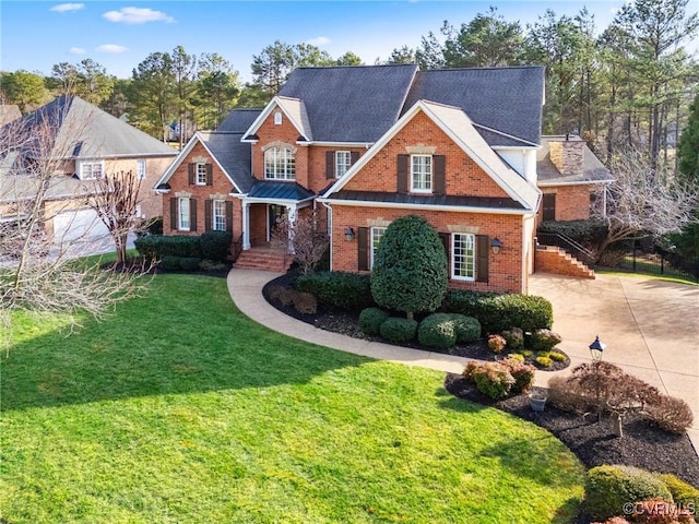 traditional-style house with concrete driveway, brick siding, and a front yard