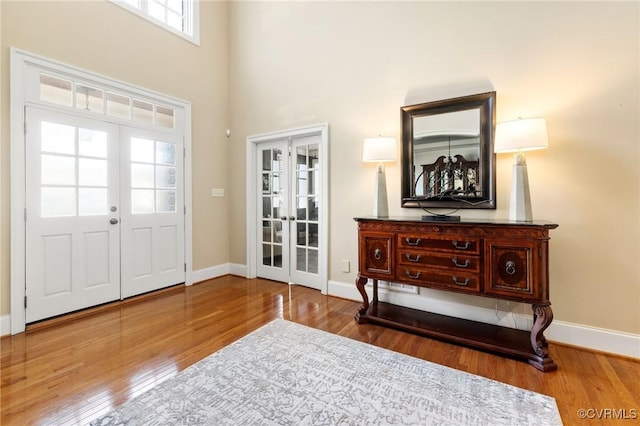 entrance foyer with hardwood / wood-style floors, french doors, and baseboards