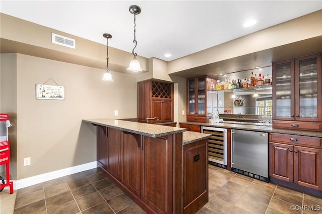 kitchen featuring visible vents, refrigerator, wine cooler, a peninsula, and glass insert cabinets