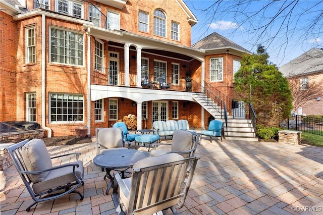 back of property with a patio, french doors, stairway, outdoor lounge area, and brick siding