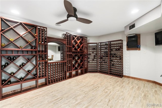 wine room featuring a ceiling fan, wood finished floors, and baseboards