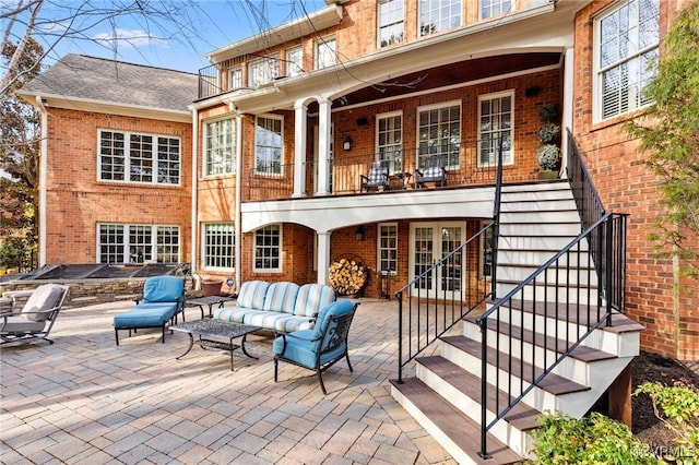 back of property with brick siding, french doors, and a patio