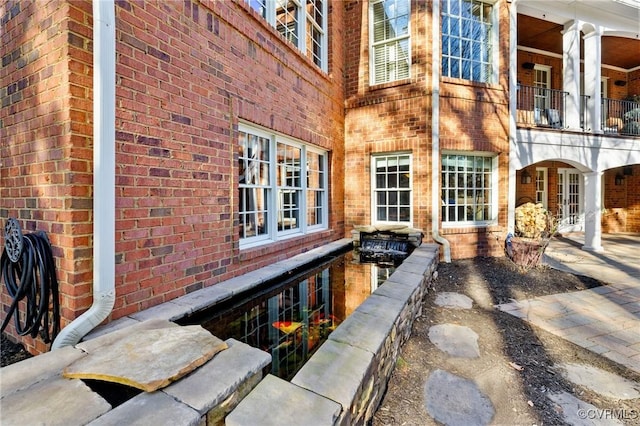 view of home's exterior featuring a balcony and brick siding