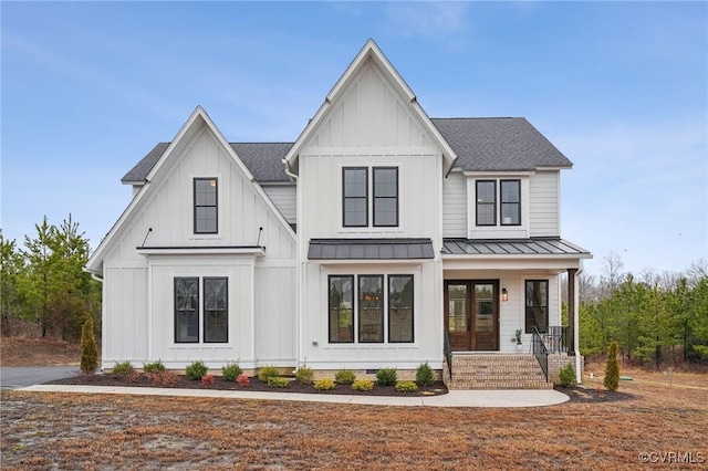 modern farmhouse style home featuring a standing seam roof, a porch, board and batten siding, and roof with shingles