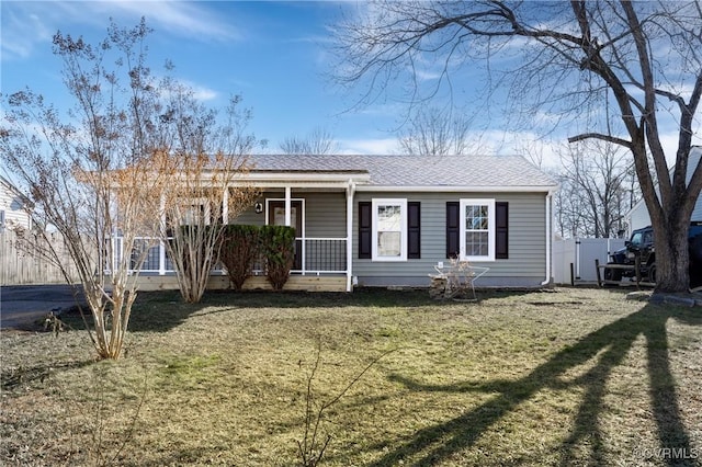 ranch-style home featuring driveway, a porch, a front lawn, and a shingled roof