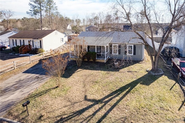 single story home featuring covered porch, dirt driveway, a front yard, and fence