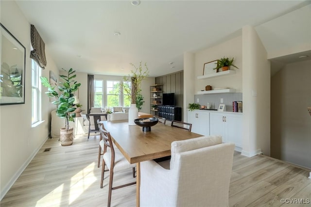 dining area featuring light wood-type flooring, visible vents, and baseboards