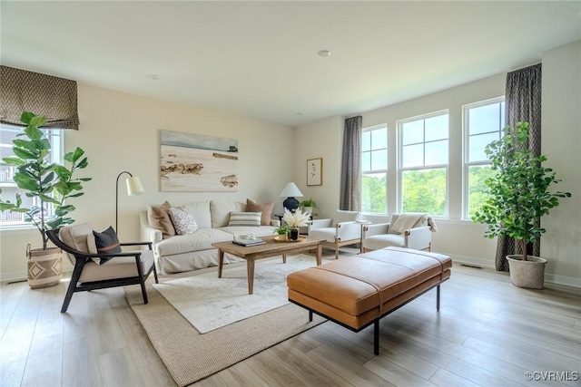 living area with light wood-style flooring and baseboards