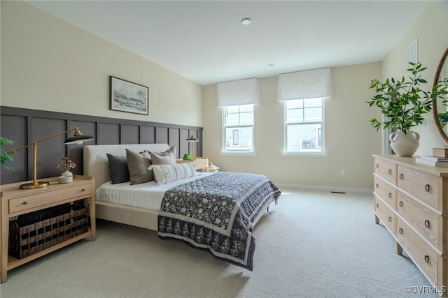 bedroom featuring light carpet and baseboards