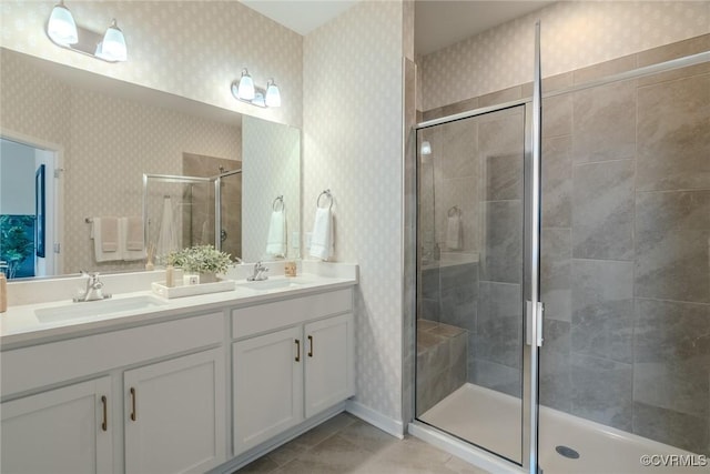 full bath featuring a stall shower, a sink, and wallpapered walls