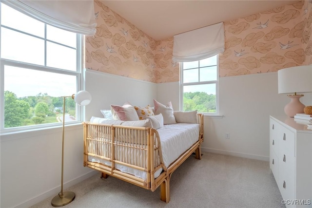 bedroom featuring wallpapered walls, baseboards, a wainscoted wall, and light colored carpet