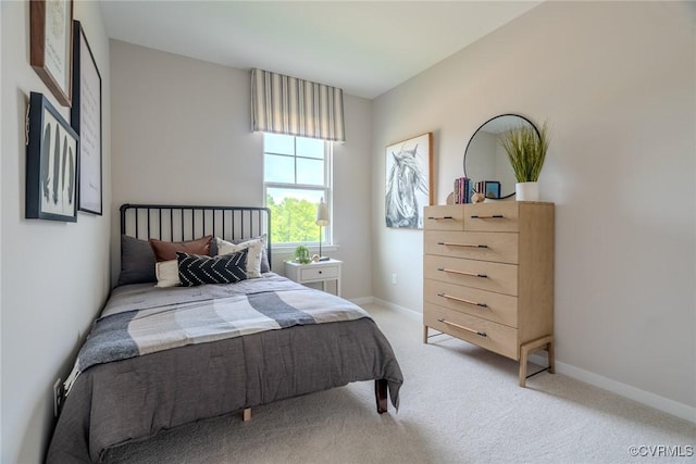 bedroom with light carpet and baseboards