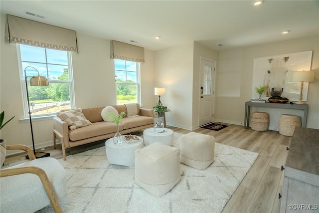 living area featuring recessed lighting, visible vents, light wood-style flooring, and baseboards