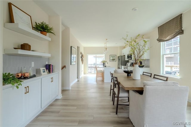 dining room with light wood finished floors and baseboards