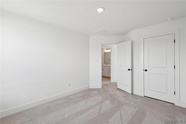 unfurnished bedroom featuring light carpet and baseboards