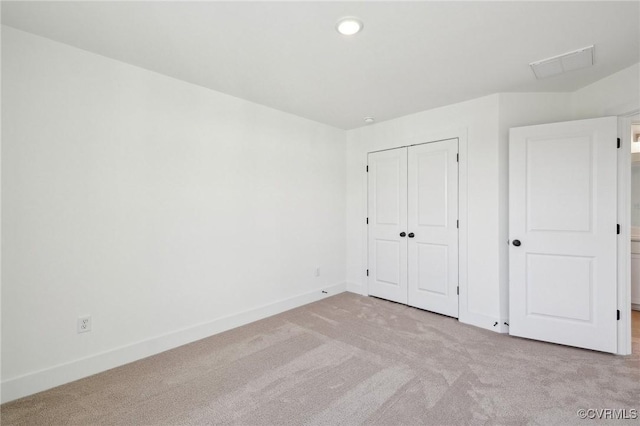 unfurnished bedroom with a closet, carpet flooring, visible vents, and baseboards