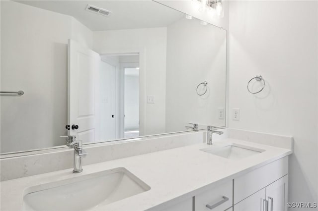 bathroom with visible vents, a sink, and double vanity