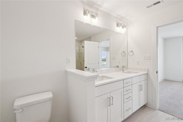 full bath with visible vents, a sink, a shower stall, and toilet