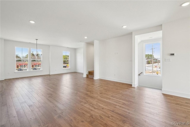 unfurnished living room featuring recessed lighting, baseboards, and hardwood / wood-style flooring