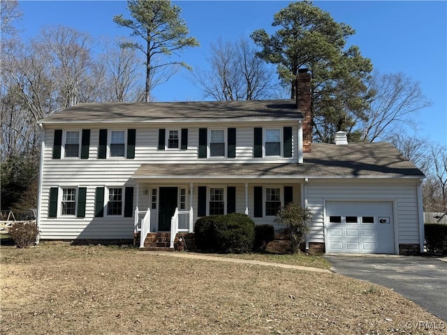 colonial-style house with a porch, an attached garage, driveway, crawl space, and a chimney