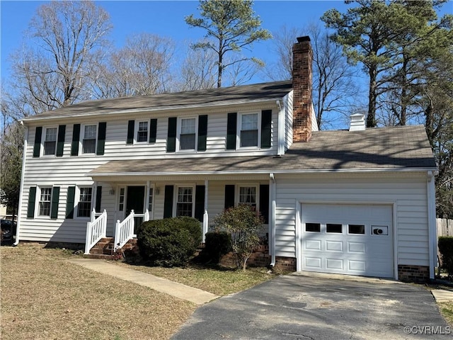 colonial house with a garage, driveway, a porch, and a chimney