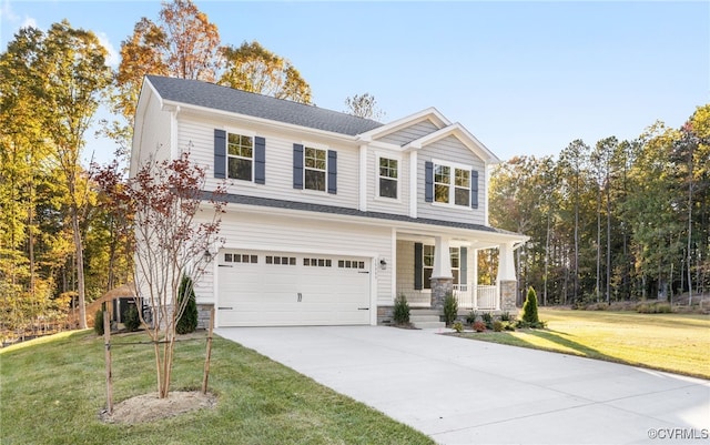 craftsman-style house featuring an attached garage, covered porch, driveway, and a front lawn