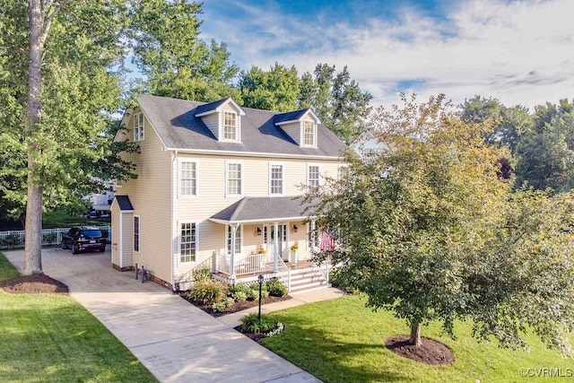 view of front of home with a porch, concrete driveway, and a front yard