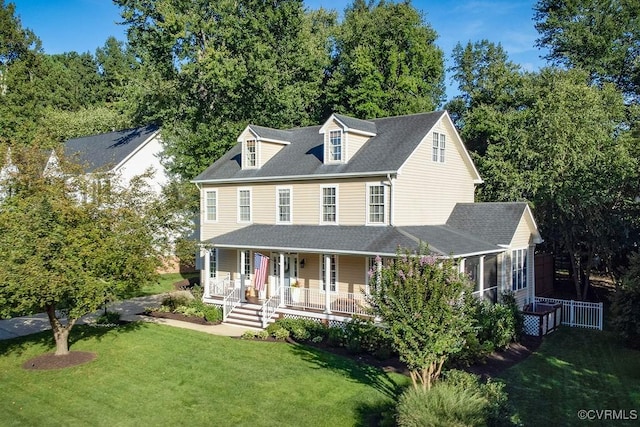 view of front of property featuring covered porch, roof with shingles, and a front lawn