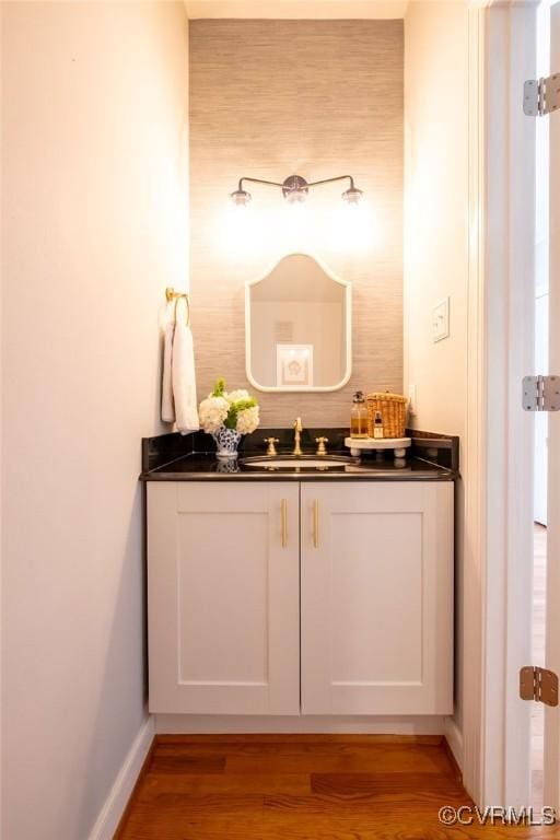 bathroom with vanity, baseboards, and wood finished floors