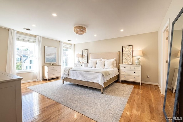 bedroom with light wood-style floors, recessed lighting, visible vents, and baseboards