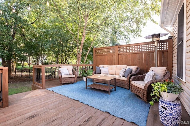 wooden deck with outdoor lounge area and fence