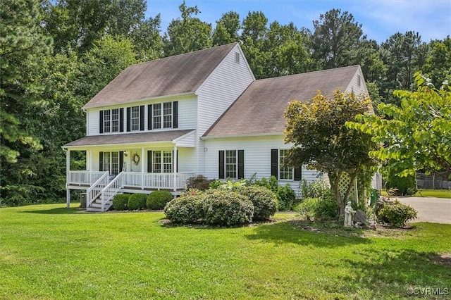 colonial inspired home with driveway, a porch, a front lawn, and a shingled roof