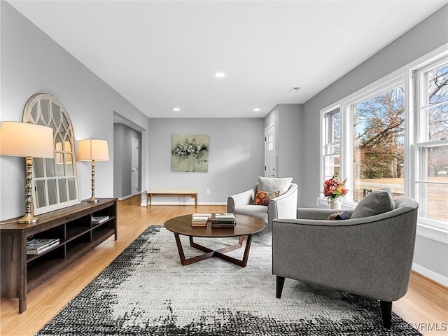 living area with recessed lighting, baseboards, and light wood finished floors