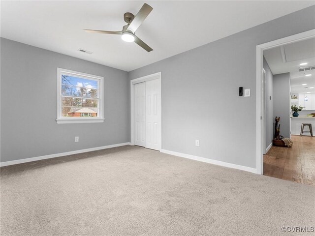 unfurnished bedroom featuring carpet floors, a closet, visible vents, and baseboards