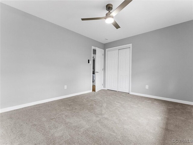 unfurnished bedroom with carpet floors, a closet, a ceiling fan, and baseboards